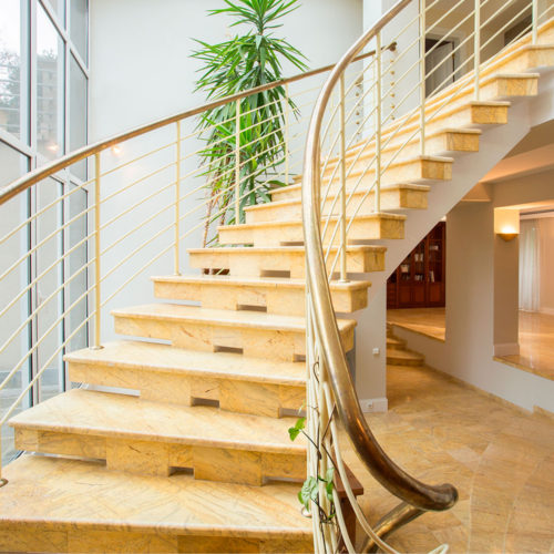 Escaleras de mármol color beige curveadas en interior