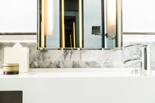 Lavabos de mármol de color blanco con espejo y otros accesorios. 