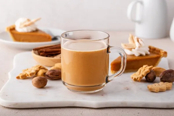 Café con especias de calabaza sobre una tabla de mármol.